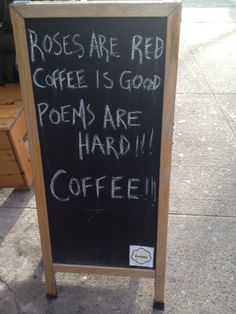 a sign on the sidewalk that says roses are red coffee is good poem are hard coffee