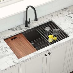 a kitchen sink with a cutting board and lemons on the counter next to it