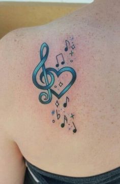 a music note tattoo on the back of a woman's shoulder