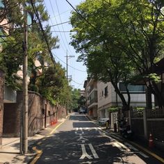 an empty street lined with trees and buildings