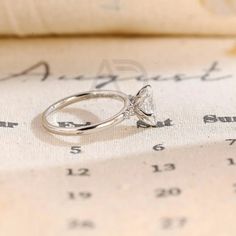 a diamond ring sitting on top of an old book