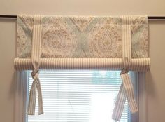 a kitchen window with an ornate valance and matching curtains