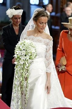 the bride is walking down the aisle in her wedding dress