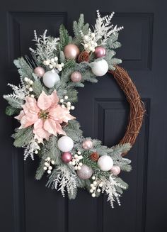 a wreath with pink and white ornaments on it