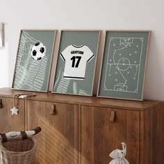 three framed soccer jerseys on top of a wooden cabinet next to a wicker basket