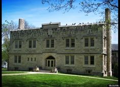 an old stone building with birds perched on the top of it's roof and windows