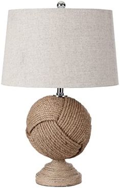 a table lamp with a rope ball on it and a linen shade over the base