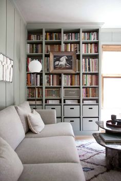 a living room filled with lots of furniture and bookshelves