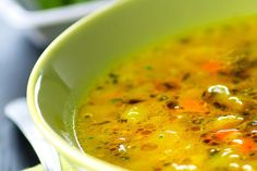 a green bowl filled with soup on top of a table