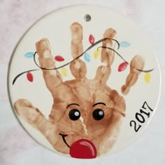 a christmas ornament with a hand print on it's face and the year 2013