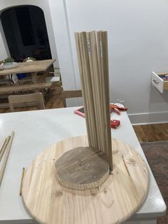 a wooden object on top of a white table in a room with other furniture and tools