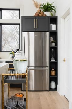 a kitchen with black cabinets and stainless steel appliances, including a silver refrigerator freezer