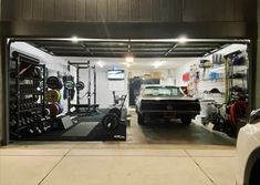 a car is parked in the garage next to a wall mounted rack with various gym equipment