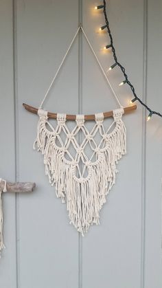 a macrame hanging on the side of a building with string lights strung around it