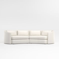 a white leather sectional sofa with rounded back cushions on an isolated background, viewed from the front