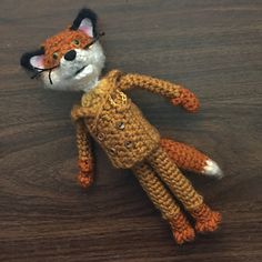 a crocheted stuffed animal laying on top of a wooden table