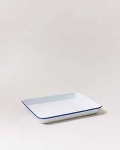 a white and blue square dish on a grey background with a black stripe around the edge