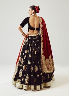 Traditional Lehenga Choli Dupatta Bridal Wedding Dress is an epitome of beauty and tradition. This stunning Lehenga choli comes in premium silk and is hand-embellished with dori, motifs, mukaish, and beads, making it your foremost priority to have a head-turning magnificent wedding look. Lehenga Choli: The choli comes in an alluring black color. The choli is in a half blouse style and it comes in premium silk fabric. The choli is beautifully adorned with shimmering embellishments and the back of Black Lehenga With Red Dupatta, Black Bridal Lehenga, Red And Black Lehenga, Lehenga Black, Dupatta Bridal, Bridle Dress, Maroon Lehenga, Traditional Lehenga, Black Lehenga Choli