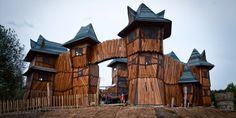 a wooden structure with many windows on top of a dirt hill next to a fence