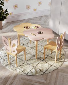 a round table with four chairs and a potted plant on the floor next to it