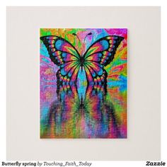 a colorful butterfly on a white wall with water reflection in the foreground and another piece of artwork behind it