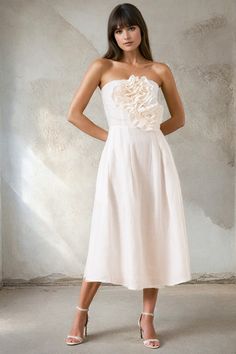 A chic strapless midi white linen dress with charming rose accents adorning the bodice, featuring invisible zippers and convenient pockets. Perfect for effortless summer style! LENGTH: Top of shoulder to hem 42" FABRICATION: 100% LINEN STYLE#. DR-21282 WHITE LINEN- WHITE *Dry Clean or wash on cold and hang flat to dry *Model is wearing size XS Chic White Linen Dress For Garden Party, White Linen Dress With Straight Neckline For Spring, Strapless Linen Dress For Spring, Spring Wedding Linen Midi Dress, Linen White Dress, Rehearsal Dinner Looks, Dinner Looks, White Linen Dress, Party Cocktail Dress