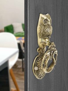 an owl door knocker is shown on the side of a wooden door with a white table and chairs in the background