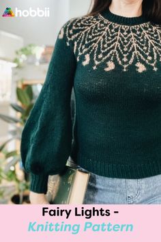 a woman wearing a green sweater and holding a book with the words fairy lights on it