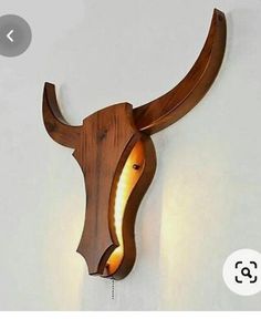 a wooden wall mounted with a light on it's side and an animal head in the middle