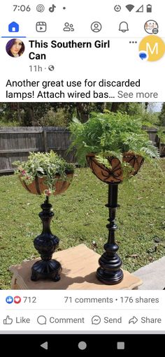 two black vases sitting on top of a wooden table in front of a fence