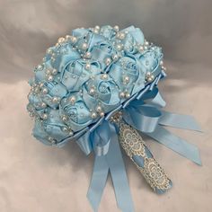 a bridal bouquet with blue ribbon and pearls