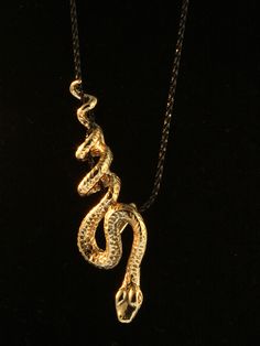 "This sinuous Python Snake winds gracefully along and down the chain as if it were suspended from a vine. The bronze snake is 2 1/4\" long and completely three dimensional with detailed scales and belly plates. Slither home with this striking beauty! The Bronze Python Snake includes a 24\" black cord but you may upgrade to an 18\" black sparkle chain via the drop down menu. This item usually ships the same or next business day. All Marty Magic Jewelry is packaged in a beautiful box, embossed wit Bronze Snake Shape Jewelry As Gift, Snake Accessories, Unique Gold Snake Necklace, Metal Snake Shape Necklace, Medusa Jewelry, Luxury Elegant Snake-shaped Necklace, Snake Jewellery, Cleopatra Jewelry, Serpent Necklace