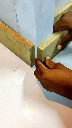 a person using a pair of scissors to cut wood with a piece of plywood