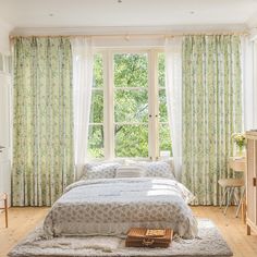 there is a bed in the room with curtains on the windowsill and a rug on the floor