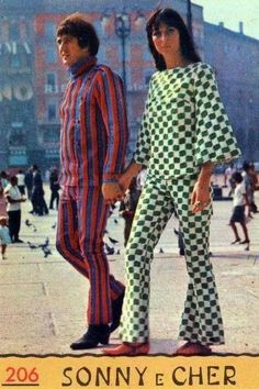 two people in matching outfits standing on the sidewalk