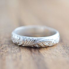 a close up of a wedding ring on a wooden table