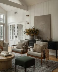 a living room with couches, chairs and a coffee table in front of a large window