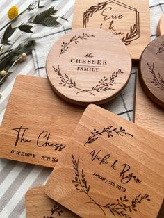 four wooden coasters with engraved names and date on them, sitting on a checkered tablecloth