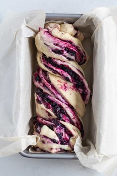 a pan filled with blueberry swirl doughnuts on top of parchment paper