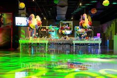 an indoor event with neon lights and decorations