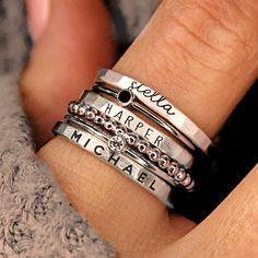 Personalized stackable ring set, engraved with names, dates, or special words. All 6 rings shown in the photos are included in this listing.  Choose between mixed metals, fine silver, or 14K yellow gold-filled for your set! MIXED METALS include: 2 - yellow gold-filled name rings 1 - fine silver name ring 2- sterling silver birthstone rings 1 - yellow gold-filled beaded ring This ring set includes three name rings, a beaded ring, and two cz rings Metal: 14k gold filled, .999 fine silver, .925 ste Stacking Name Rings, How To Make Silver Rings, Stack Rings Silver, Family Ring Designs, Mom Rings Stackable, Mom Rings, Personalized Stackable Rings, Mothers Ring Stackable, Stackable Name Rings