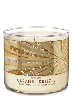 a glass candle with gold foil on the lid and inside, in front of a white background