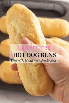 there is a person holding a hot dog buns in front of some buns