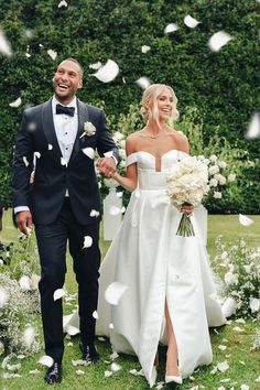 a bride and groom are walking through confetti