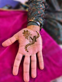 a woman's hand with henna tattoos on her left arm and palm in the middle