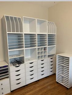 an empty room with many white drawers and shelving units on the floor next to each other