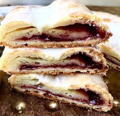 three pastries stacked on top of each other with icing and jelly in them