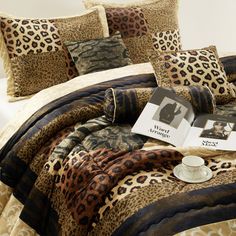 a leopard print comforter set with coffee cup and book on the bed in front of it