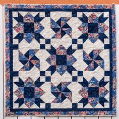 a blue and white quilt hanging on the wall