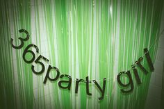 there is a green curtain with the word party on it and black letters hanging from it